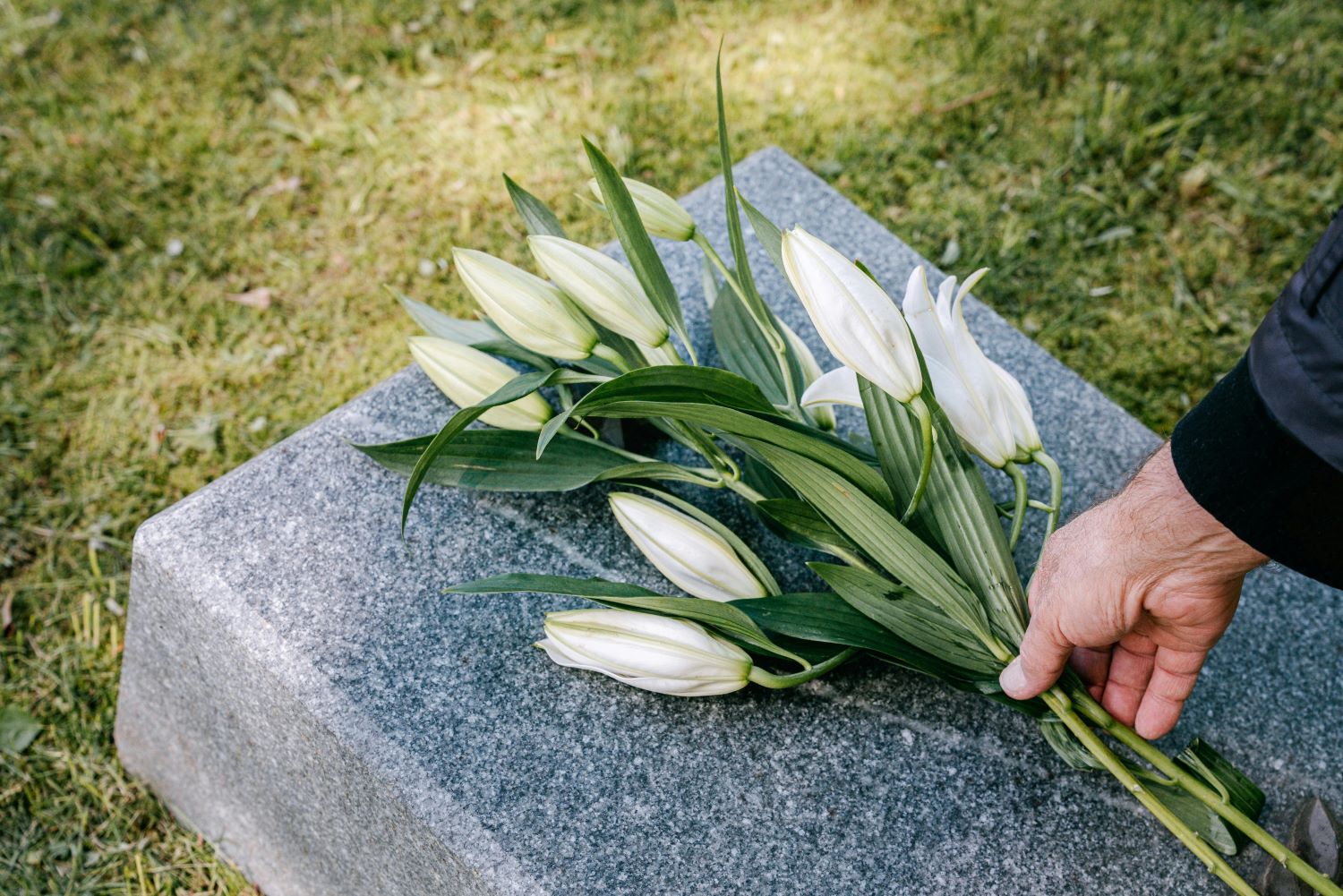 image of flowers being placed on a headstone